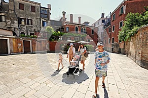 Woman with kids walk in Campiello Novo O Del Morti street in Venice, Italy