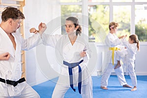 Woman in kimono honing punching techniques during kumite with man