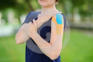 Woman with kinesio tape on her shoulder. Kinesiology, physical therapy, rehabilitation