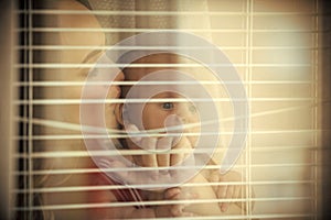 Woman kiss child at window shutters