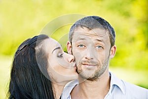 Una mujer besos en sobre el rostro hombre 