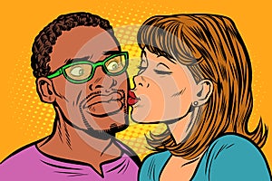 Woman kisses a man. multi-ethnic couple. embarrassment