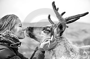Woman kissing a cute reindeer.