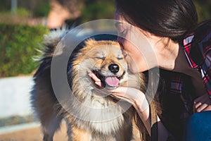 Woman kissing dog with copy space for text