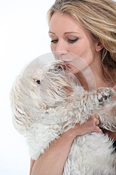 Woman kissing dog.