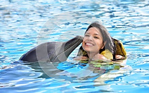 Woman kissing dolphin in pool