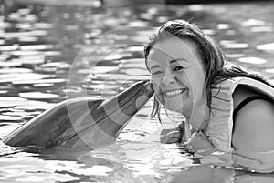 Woman kissing dolphin in pool