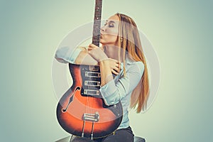 Woman kissing electric guitar devoted