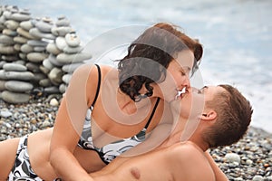 Woman is kissing her man on sea coast