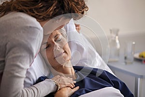 Woman kissing her mother at hospital