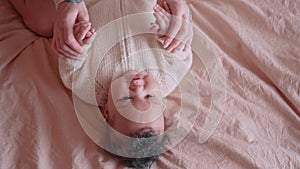 A woman is kissing her newborn daughter.