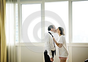 Woman kissing husband goodbye in the morning