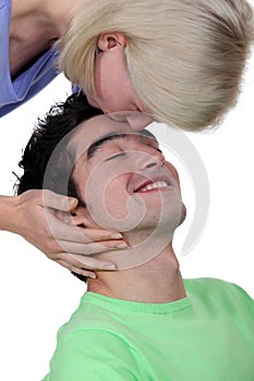 Woman kissing a man's forehead