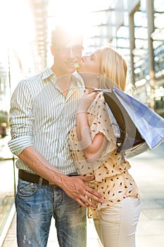 Woman kissing Man at shopping and is happy