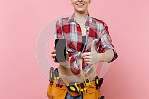 Woman with kit tools belt full of instruments holding showing camera mobile phone with blank black empty screen display