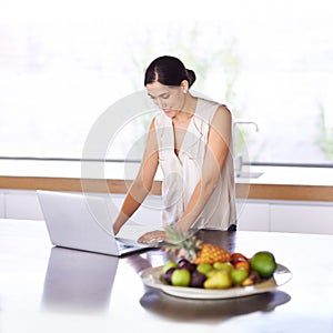 Woman, kitchen and browse website on laptop for recipe ideas or nutritional information for meal planning. Female person