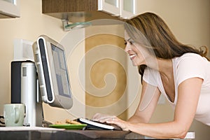 Woman in kitchen with computer