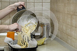 woman in kitchen cooking pasta