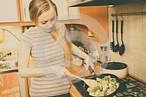 Woman cooking stir fry frozen vegetable on pan photo