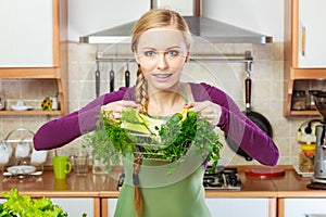 Woman in kitchen having vegetables holding shopping basket