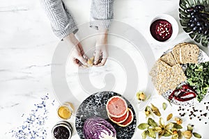 Woman in the kitchen and her healthy food eating selection: fruits, vegetables, super food, seeds, marble background copy space. photo