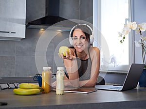 woman in the kitchen at home is preparing fruit or a healthy smoothie and having fun