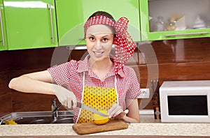 Woman in the kitchen with knife and lemon