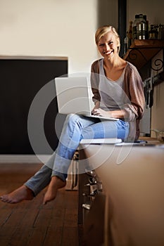 Woman in kitchen, laptop and remote work, smile in portrait and writer for blog, freelancer and copywriting. Working