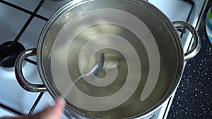 Woman in the kitchen near a gas cooker in a saucepan dumplings for cooking