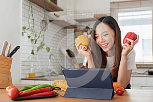 woman in the kitchen preparing materials ready to cook looking at recipes on tablet