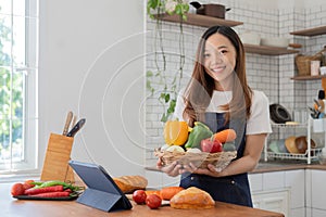 woman in the kitchen preparing materials ready to cook looking at recipes on tablet