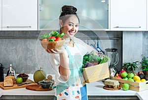 Woman in kitchen with various kind of vegetable and fruits that