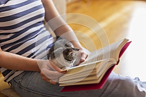 Woman and kitten reading a book