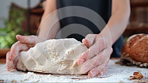 Woman kneading dough for bread, pasta or pie, closeup view of female hands on kitchen table, cooking