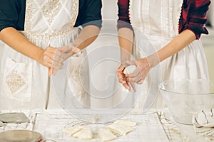 Woman kneading dough on kitchen board