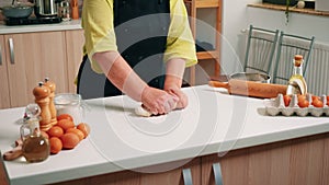 Woman kneads the dough on table