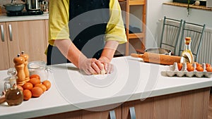 Woman kneads the dough on table