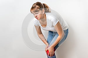 Woman with knee pain is holding her aching leg