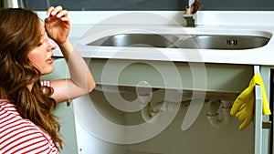 Woman kneeing in front of sink