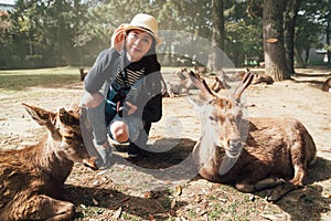 Woman kneeling down around resting deer