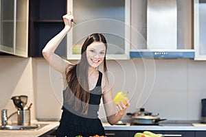 Woman with a knife begins to cut the fresh pepper.