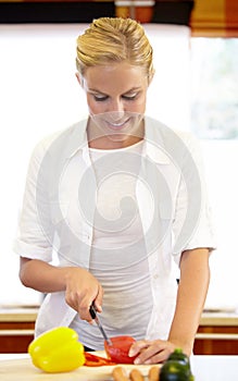 Woman, knife and cutting of ingredient in kitchen for vegan, vegetarian and dinner. Happy person, smile and