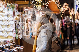 Woman with knit hat looking for souvenir at christmas market stall