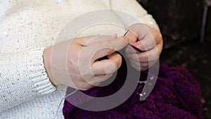 Woman knits jacket with knitting needles. Women`s hands and knitting close-up