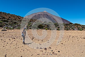 Woman on La Canada de los Guancheros dry desert plain with view on volcano Pico del Teide, Mount El Teide National Park, Tenerife photo