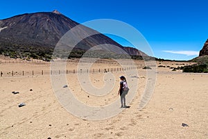 Woman on La Canada de los Guancheros dry desert plain with view on volcano Pico del Teide, Mount El Teide National Park, Tenerife photo