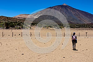 Woman on La Canada de los Guancheros dry desert plain with view on volcano Pico del Teide, Mount El Teide National Park, Tenerife photo