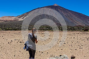 Woman on La Canada de los Guancheros dry desert plain with view on volcano Pico del Teide, Mount El Teide National Park, Tenerife photo