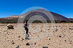 Woman on La Canada de los Guancheros dry desert plain with view on volcano Pico del Teide, Mount El Teide National Park, Tenerife photo