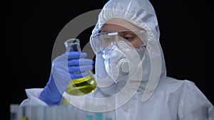 Woman laboratory assistant holding flask with flammable liquid, toxic igniter